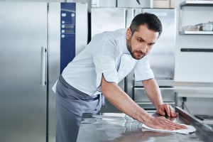 AIG man cleaning kitchen counter